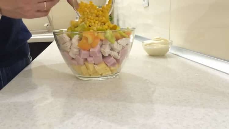 To make a salad with pineapple chicken and corn, add all the ingredients to the bowl