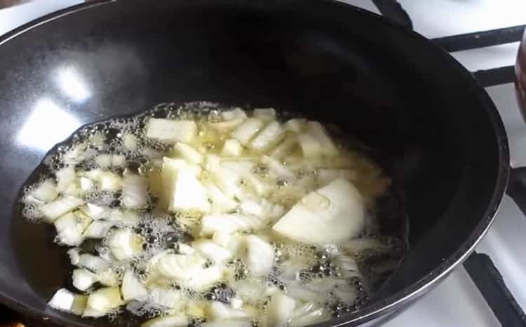 Fry onions to make cheese soup with mushrooms