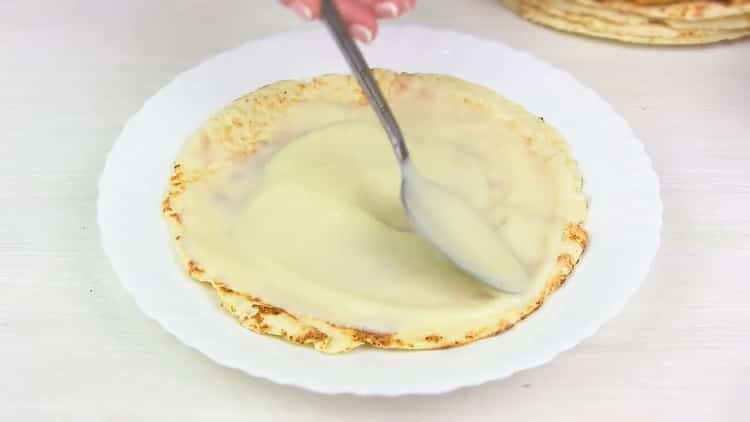 To make a Napoleon cake in a pan, grease the cakes with cream