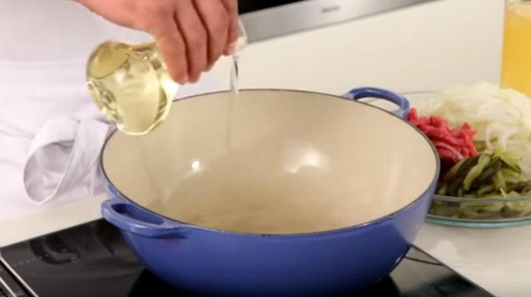 We heat vegetable oil in a large stewpan.