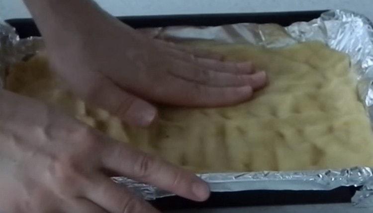 tapisser la plaque de cuisson sur la majeure partie de la pâte. faire de petits côtés.
