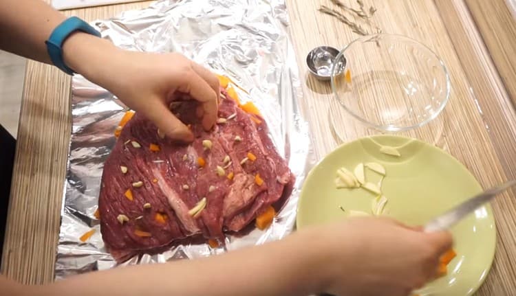 Nous farcissons la viande avec de l'ail et des carottes.