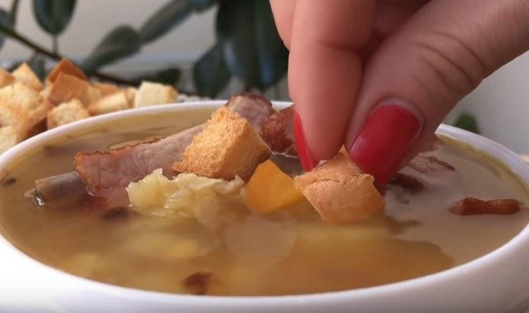 La sopa de guisantes con costillas ahumadas generalmente se sirve con picatostes.