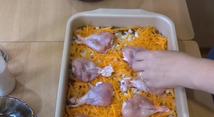 Répartir les pilons de poulet sur la couche de carottes.