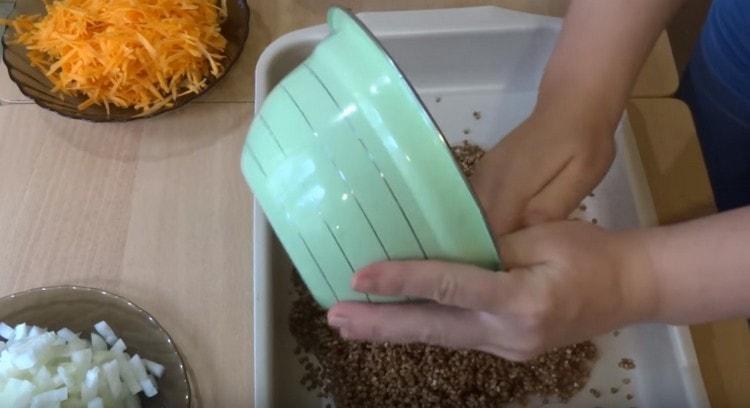 We place washed buckwheat in a baking dish greased with vegetable oil.