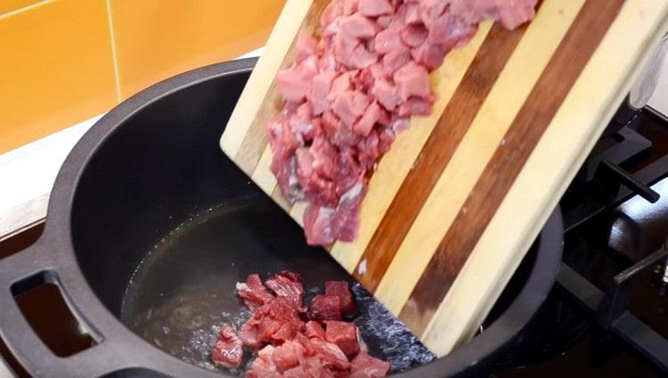 Lorsque l'ail est doré, retirez-le et mettez la viande dans le chaudron.