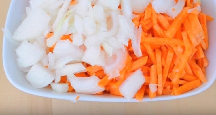 Nous coupons les oignons en demi-anneaux et les carottes en lanières.
