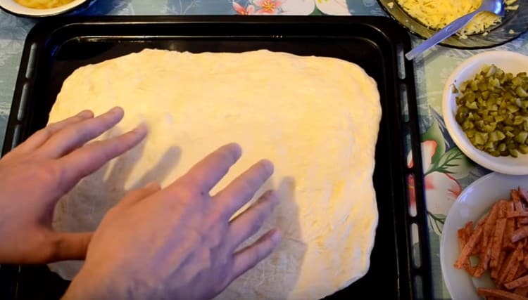 Sur une plaque à pâtisserie graissée, étendre la moitié de la pâte préparée.