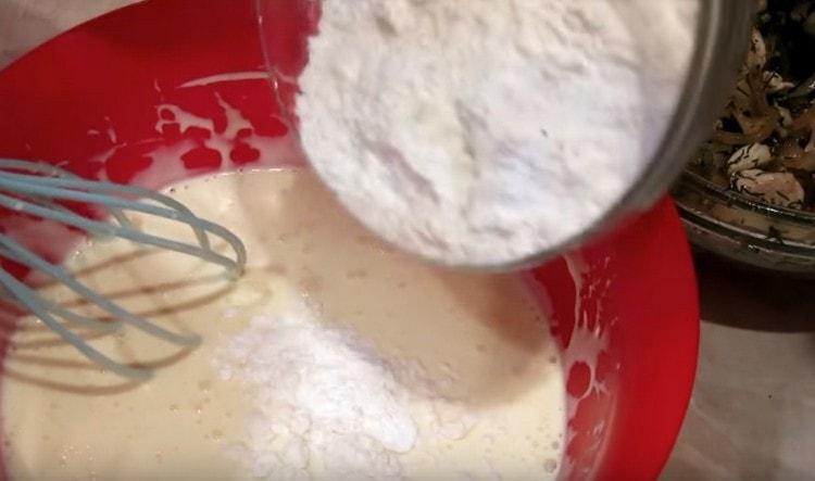 Pour flour with baking powder to the liquid base for the dough.
