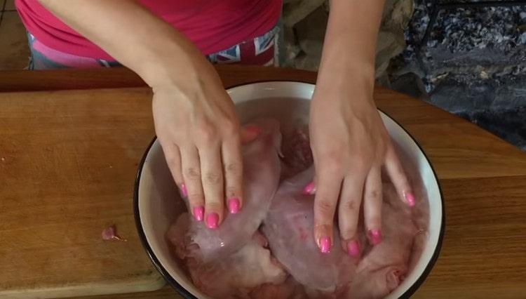 We put the pieces of the rabbit in a bowl and fill it with water so that excess blood comes out of the meat.