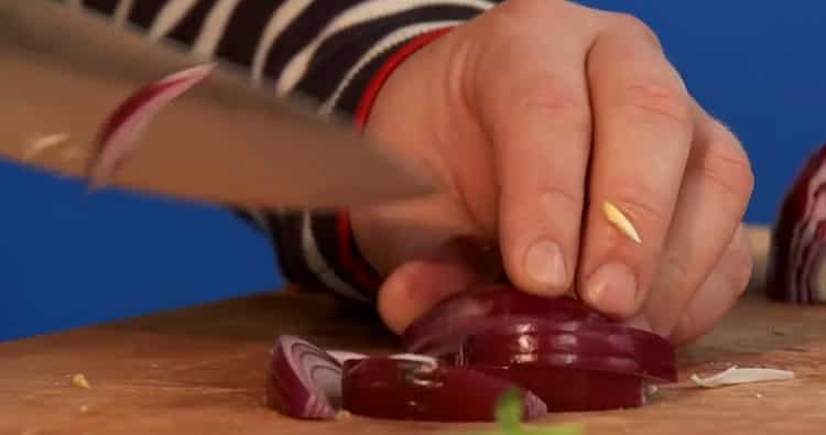 Para cocinar bagre en el horno, picar cebollas