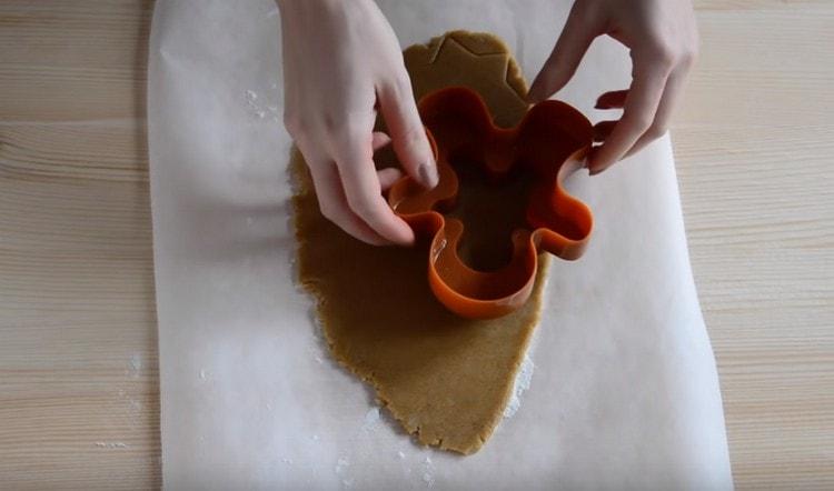 Cut cookies from the dough using cookie cutters.