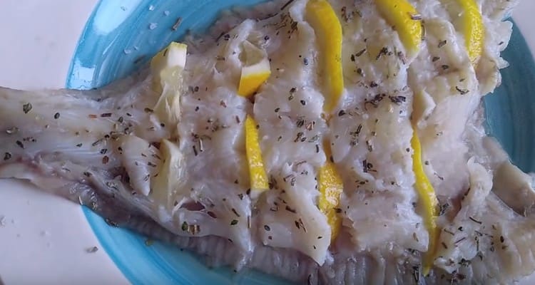 Insert the lemon slices into the incisions made on the flounder.