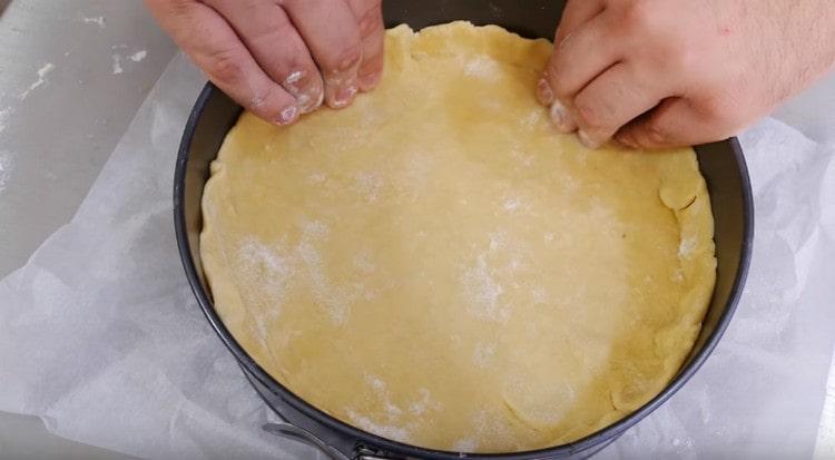 We put the dough into shape, make the sides.