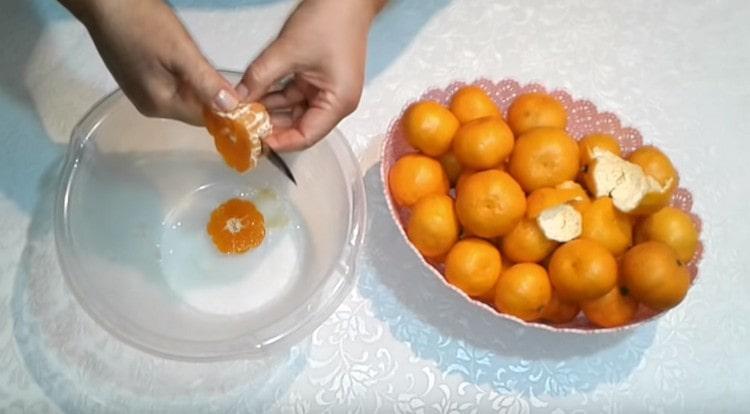 Mandariner rengøres og skæres i tre stykker hver.
