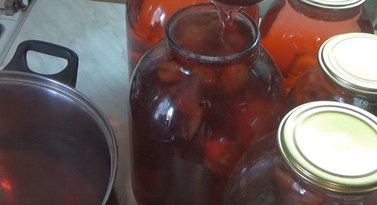 Immediately carefully pour the plums with hot syrup and roll up the jars.