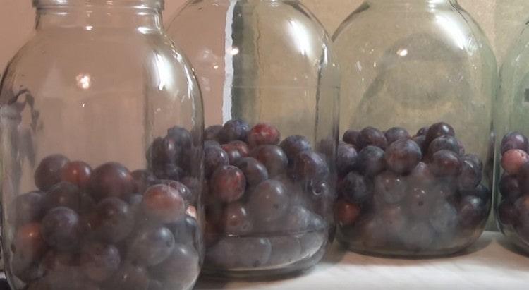 We lay a third of each jar with plums.