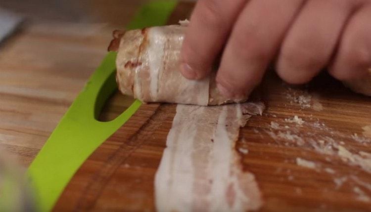 Enveloppez une côtelette presque terminée dans une fine bande de bacon.