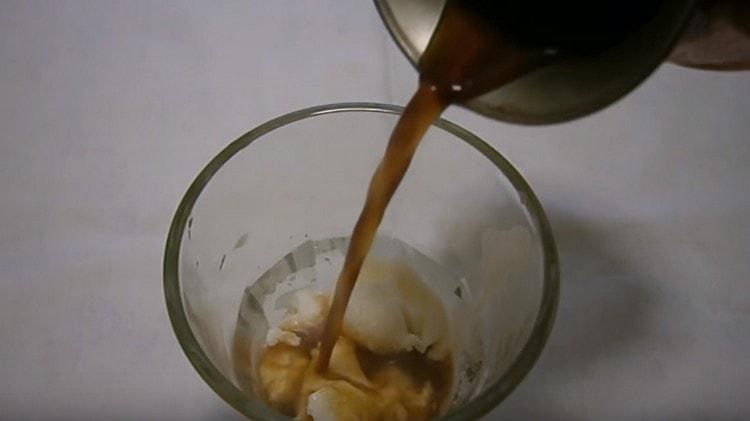 Gently pour coffee into an ice-cream glass.