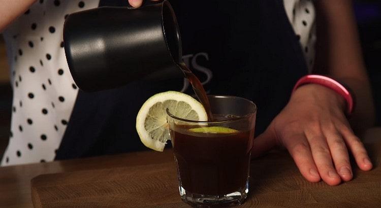 Vierte la bebida terminada en un vaso con un círculo de limón.