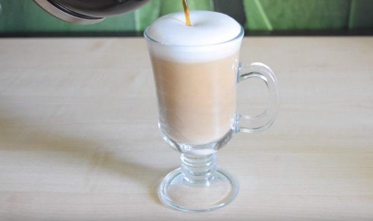 Después de la formación de la espuma, agregue una corriente delgada en la espuma de café con leche.