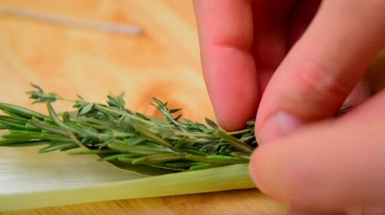 Preparing a garnish bouquet: put onion leaves, onion, sprigs of thyme and rosemary in leek.