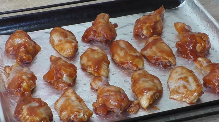 We spread the wings on a baking sheet so that they do not touch each other, and send to the oven.