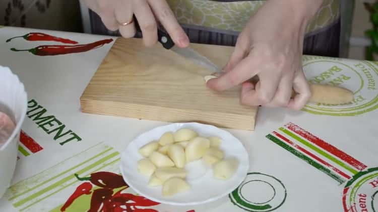 To cook chicken legs in the oven, chop the garlic