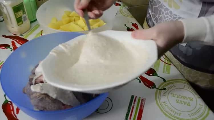 Para cocinar las patas de pollo con papas en el horno, mezcle la carne con las especias.