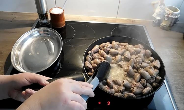 Nous répandons les cœurs de poulet dans la poêle et les faisons frire jusqu'à ce que presque tout le liquide se soit évaporé.