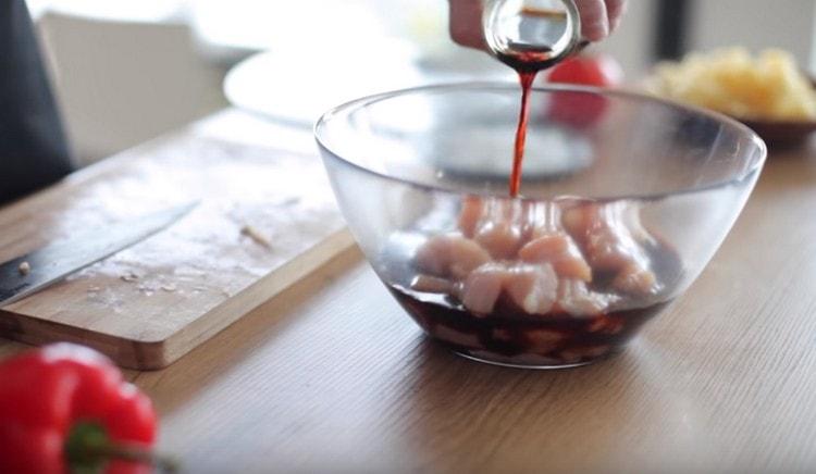 Envoyez des morceaux de poulet dans un bol et faites-les mariner dans une sauce soja.