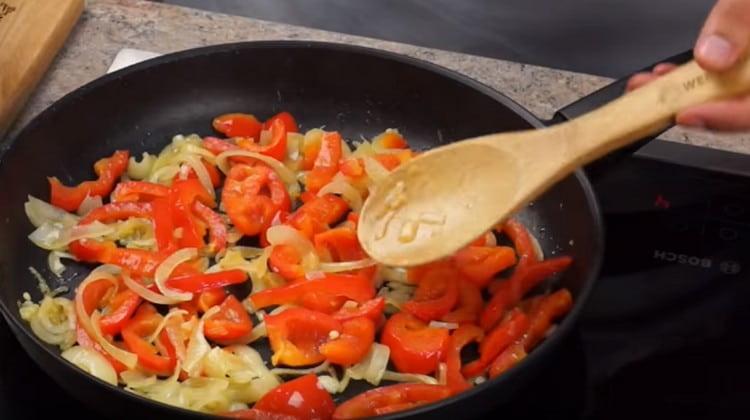 En lugar de pollo, ahora esparcemos las verduras en una sartén y freímos hasta que las cebollas estén transparentes.