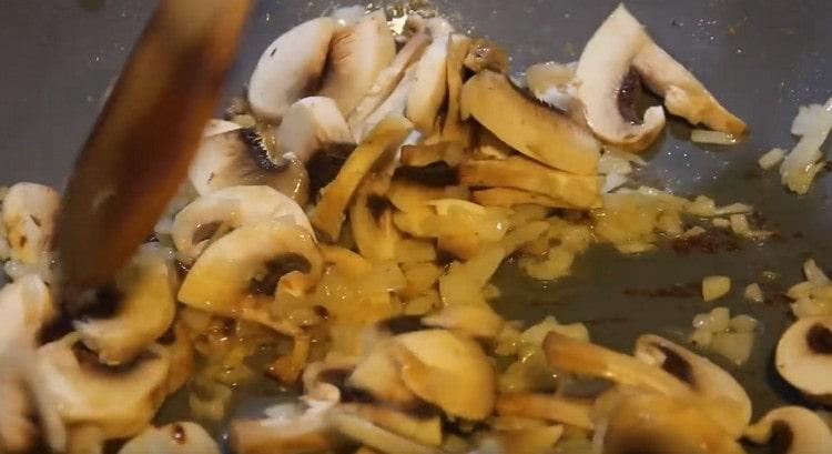 Ajouter les champignons à l'oignon, les faire frire jusqu'à ce que la couleur change.