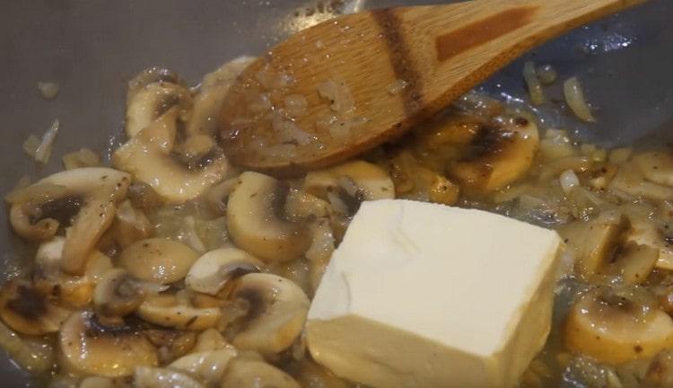 Nous répandons un morceau de fromage à la crème dans une casserole.