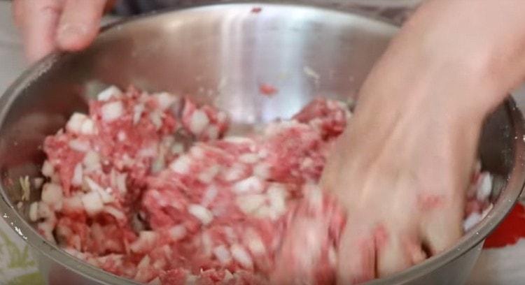 Ajouter l'oignon, l'eau à la viande hachée et bien mélanger.