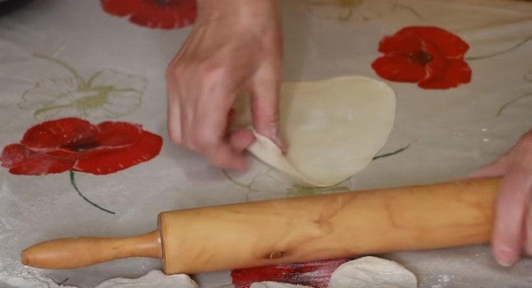 Rouler la pâte dans une saucisse, la couper en morceaux et rouler chacune d’elles avec un rouleau à pâtisserie.