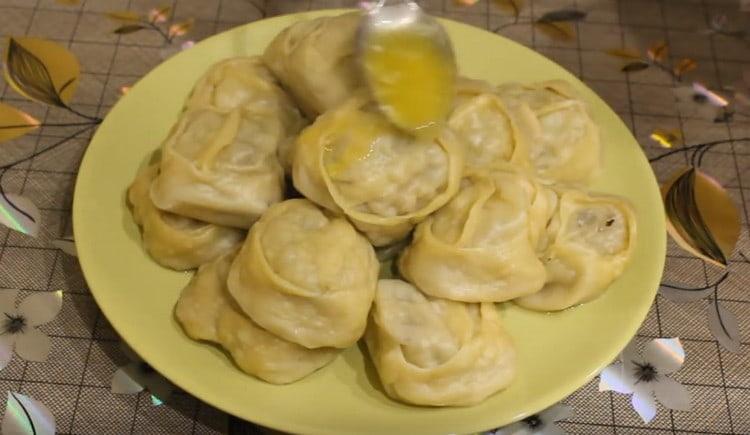 Hete manti met pompoen en gehakt wordt gegoten met gesmolten boter.