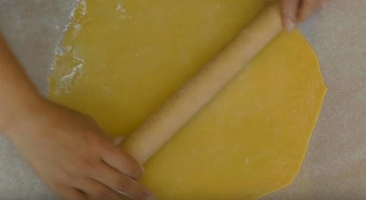 Rouler finement chaque boule de pâte sur du parchemin.