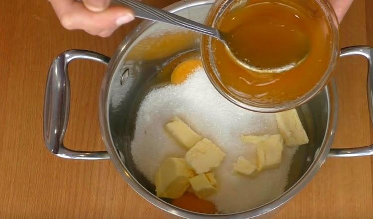 En una cacerola combinamos mantequilla, azúcar, huevos y miel líquida.
