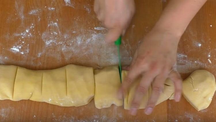 We roll the finished dough into a sausage and divide it into 8 identical pieces.