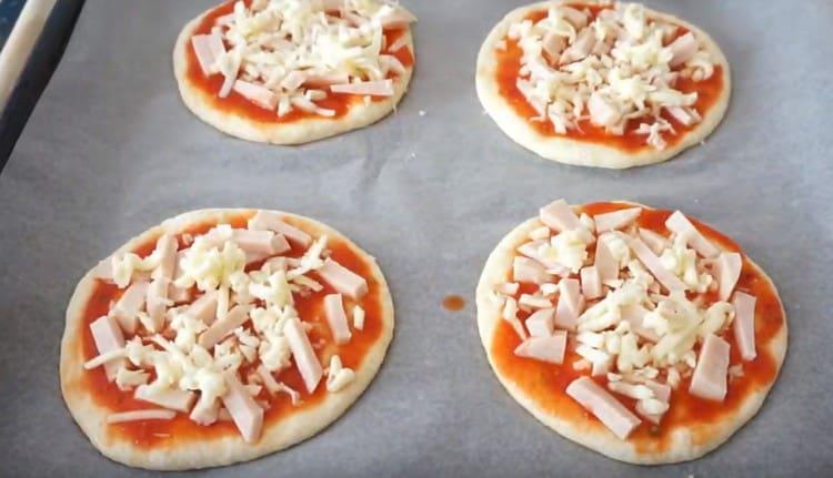 Na svaku mini pizzu rasporedite pršut i sir.