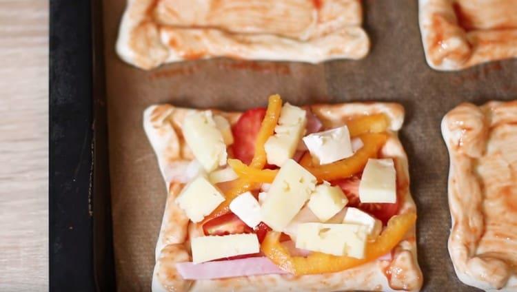 Agregue la cebolla picada y el pimiento dulce, así como el queso en rodajas.