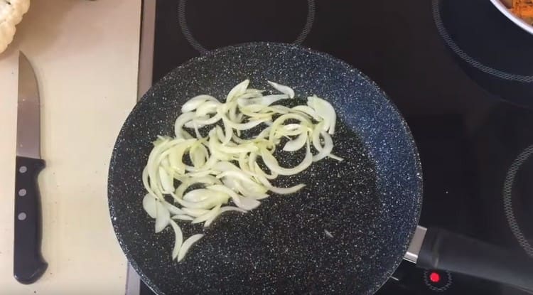 After the carrots, put the onion, sliced ​​in half rings, into the pan.