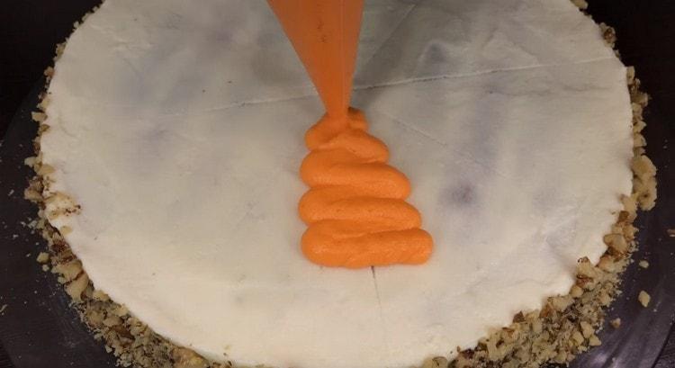 Usando una bolsa de pastelería, exprima una decoración con forma de zanahoria en el pastel.