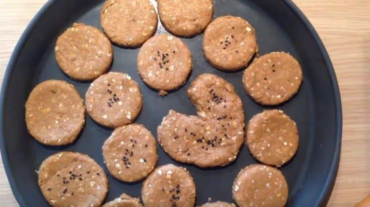 We spread the cookies on a baking sheet and put in the oven.