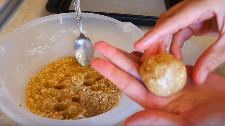 Nous roulons la boule de la pâte et l'envoyons sur une plaque à pâtisserie recouverte de parchemin.