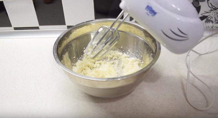 Battre le beurre ramolli avec du sucre avec un mixeur.