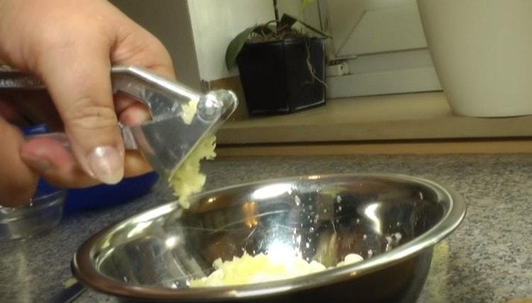 Squeeze the garlic into sour cream through a press.