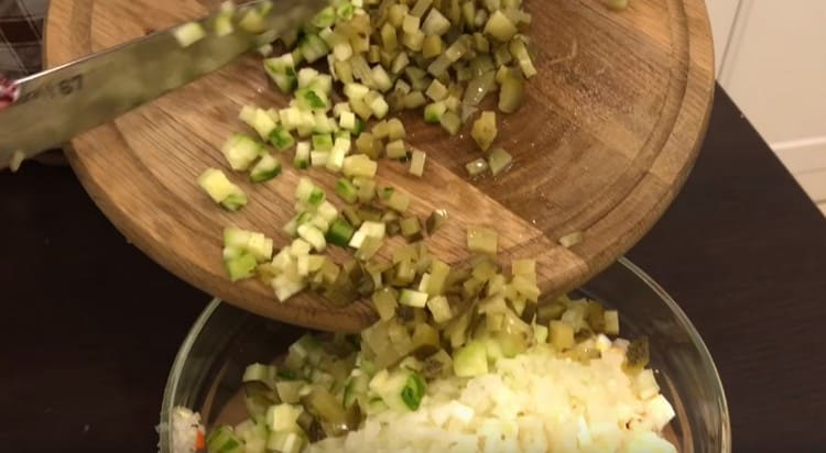 Izrežite svježi i kiseli krastavac, dodajte u salatu.