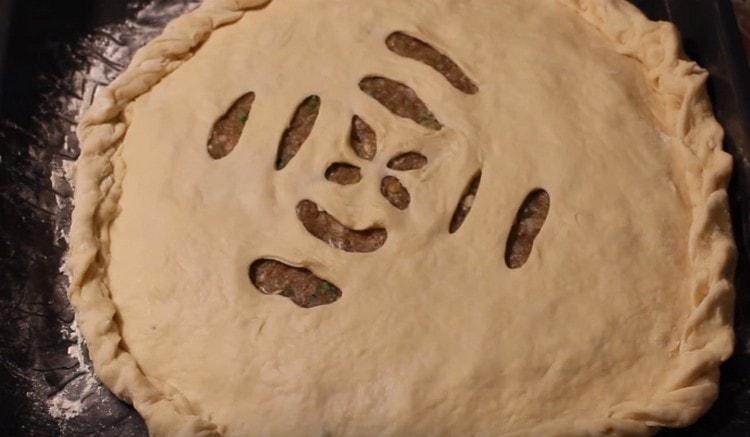 We lay out the second layer of dough over the filling, pinch the edges of the pie.